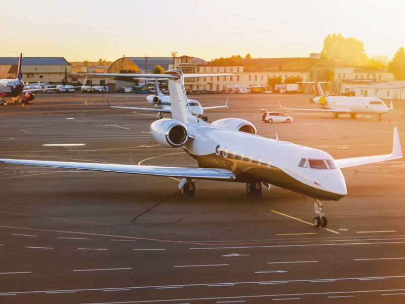 Private jet aircraft at airport. Illuminated by the sun at sunset. Top and side view.
